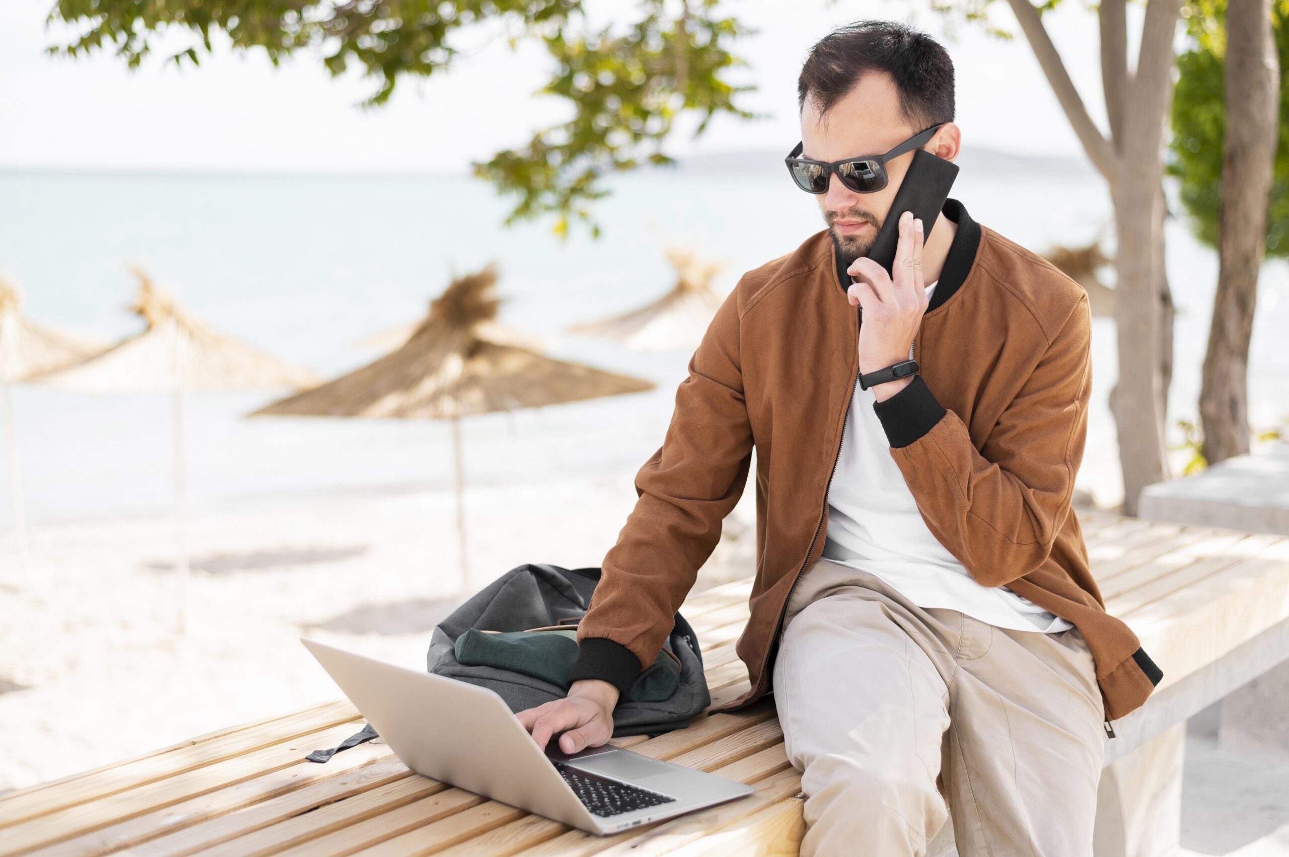 front-view-man-working-laptop-beach